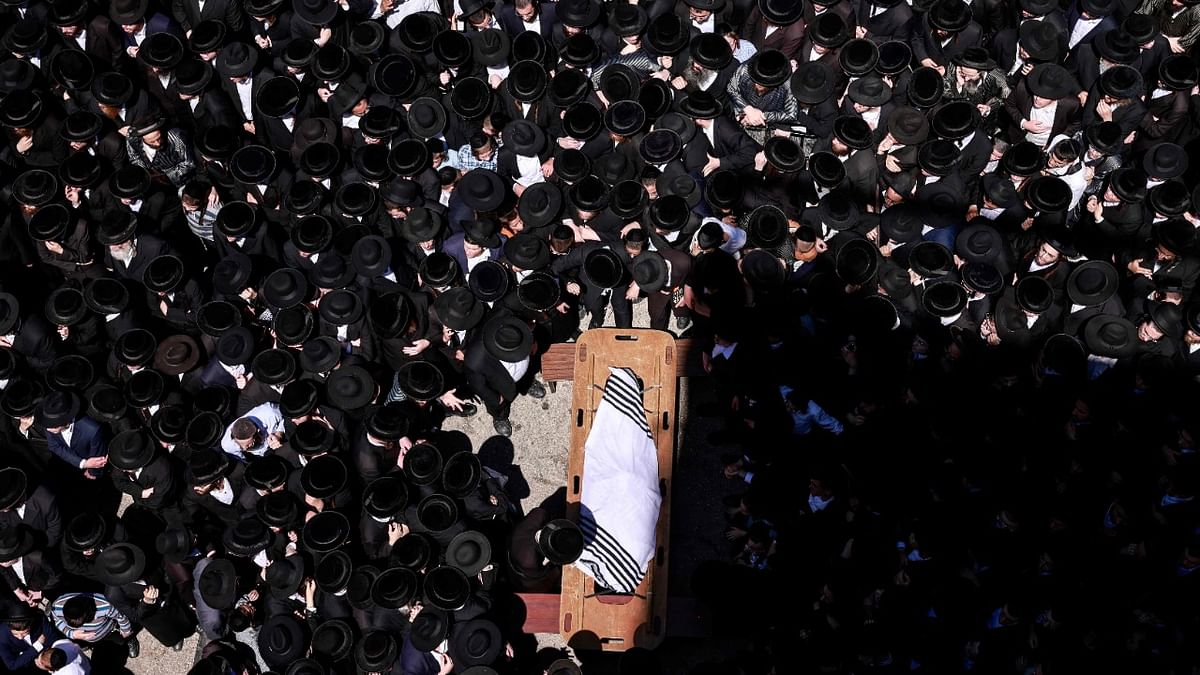 Jewish ultra-Orthodox mourners gather around the body of prominent Rabbi Yitzchok Tuvia Weiss, during his funeral procession in Jerusalem. Credit: AFP Photo