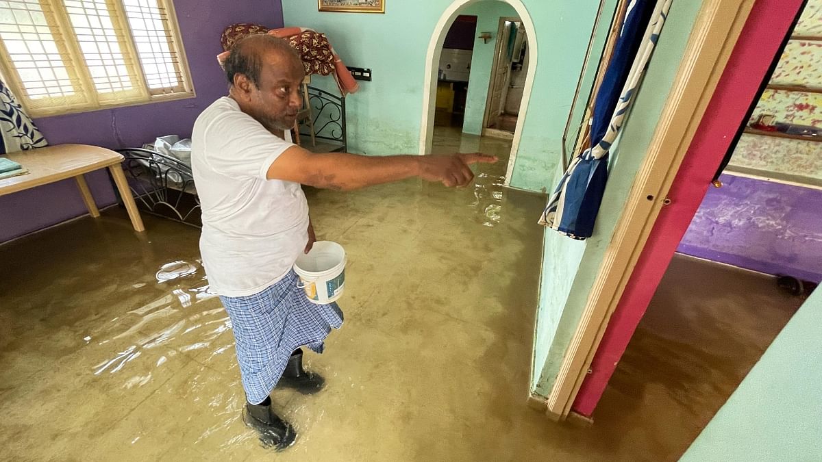 A local gestures as he stands in his flooded house in Bengaluru amid the incessant rains. Credit: Pushkar V/DH Photo