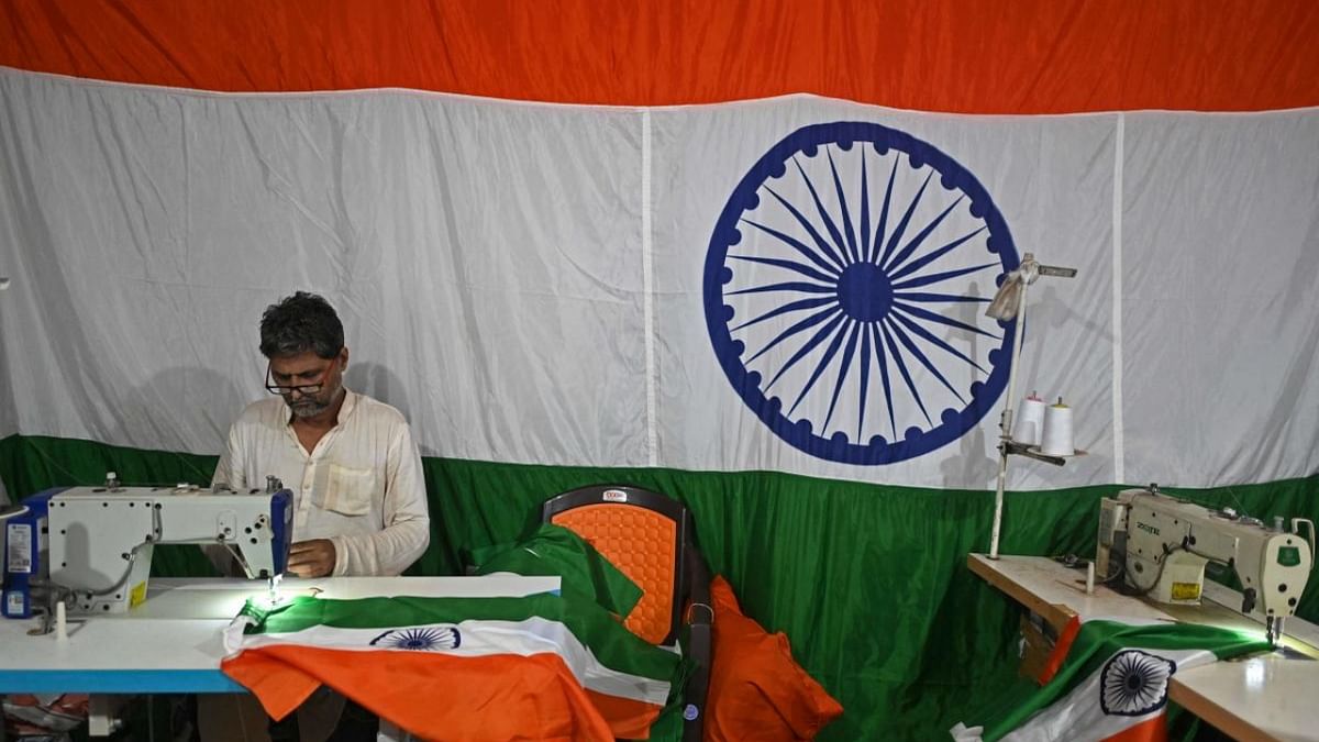 A worker sews an Indian national flag from the lengths of printed tricolour cloth at the workshop of ‘Bharat Handloom Cloth House’ ahead of country's Independence Day celebrations, in the old quarters of New Delhi on August 3, 2022. Credit: AFP Photo