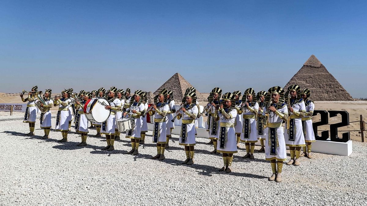 Marching band members dressed in ancient Egyptian clothing perform ahead of the Pyramids Air Show 2022 at the Giza Pyramids Necropolis. Credit: AFP Photo