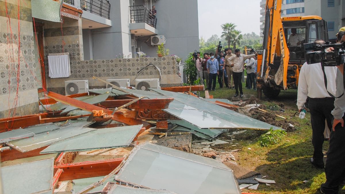 Uttar Pradesh government officials used a bulldozer to remove encroachment done by BJP leader Shrikant Tyagi outside his residence in Noida on August 8. Credit: PTI Photo