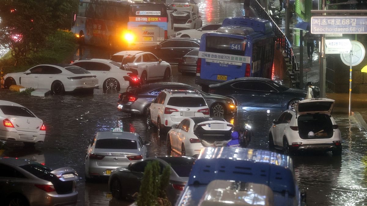 Deserted cars and buses were scattered across streets as the water receded. Workers cleared uprooted trees, mud and debris with excavators and blocked off broken roads and pavement. Credit: Reuters Photo