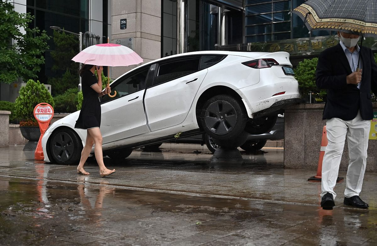 A car damaged by flood water is seen on the street after heavy rainfall at Gangnam district in Seoul. Credit: AFP Photo