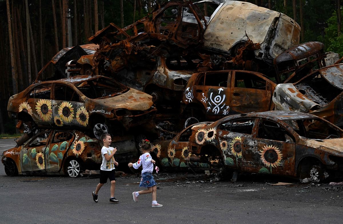 Children play at the symbolic cemetery of cars shot by Russian troops , some painted by local artists, in Irpin. Credit: AFP Photo