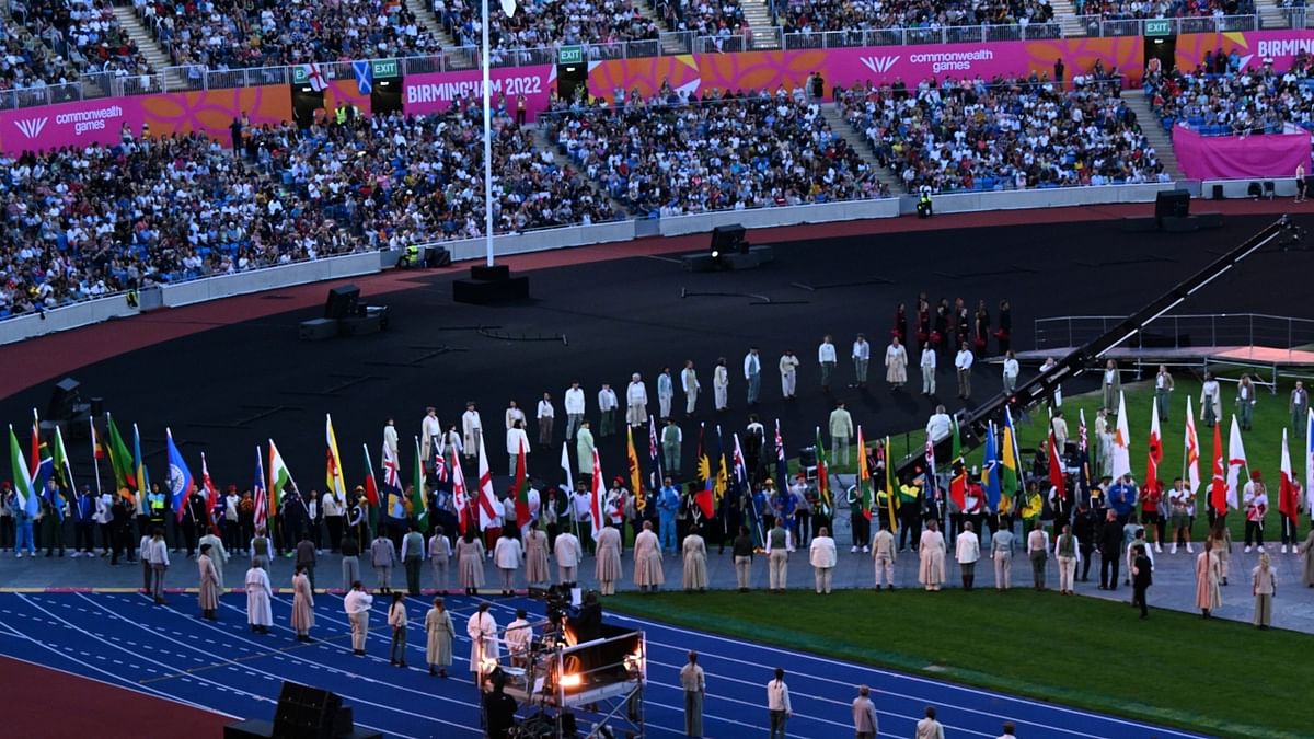 The flag bearers of the participating countries hold the national flags of their respective countries during the closing ceremony of the Commonwealth Games 2022 (CWG), at Alexander Stadium in Birmingham. Credit: PTI Photo
