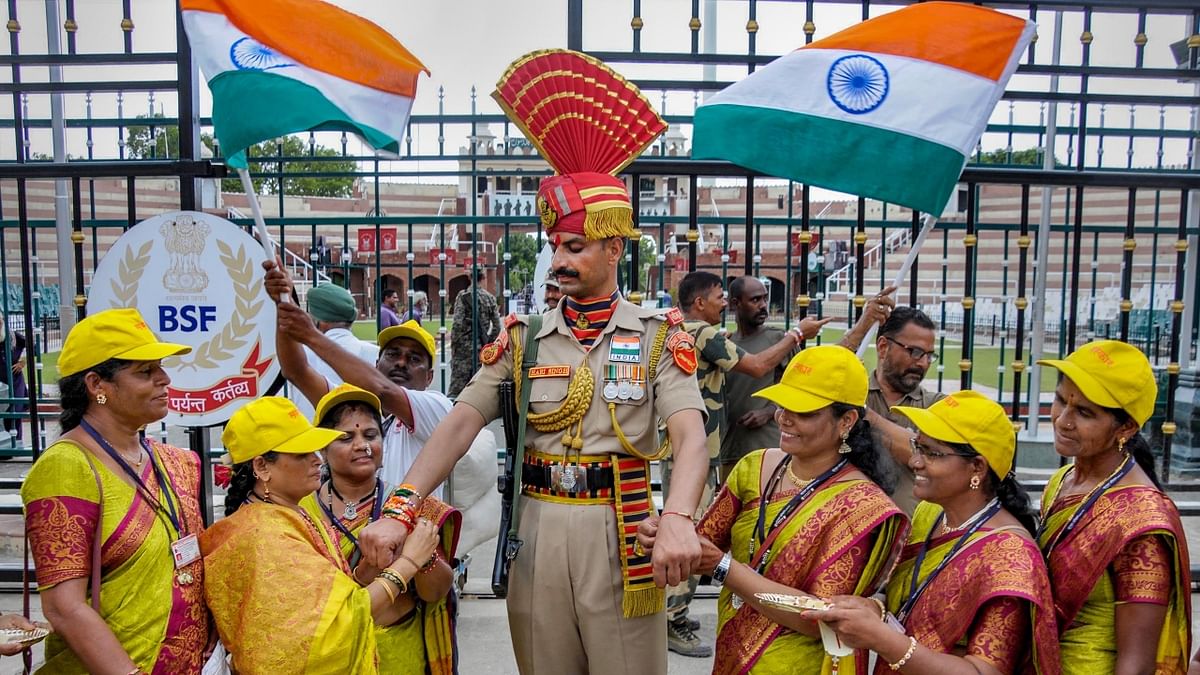 Women tie 'rakhis' on the wrists of a Border Security Force (BSF) personnel during a ceremony to mark 'Raksha Bandhan' festival, at the Wagah Border. Credit: PTI Photo