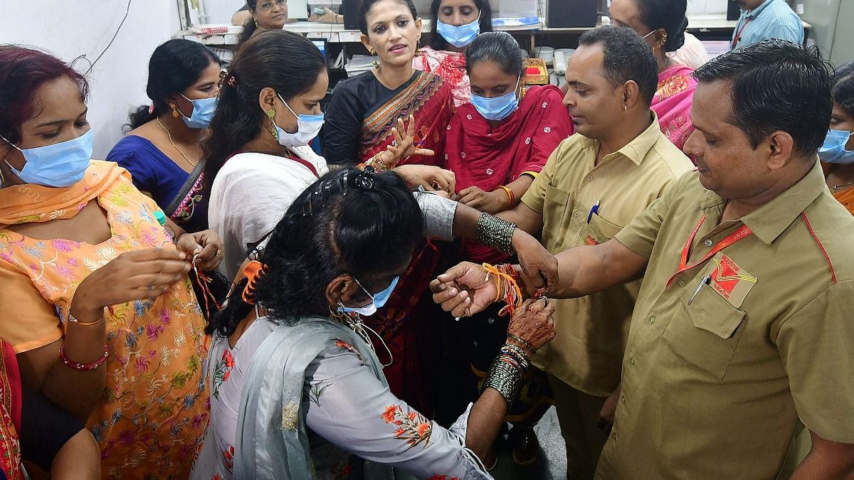 Sex workers from Kamathipura tied 'rakhi' on the wrists of employees of a post office during 'Raksha Bandhan' celebrations, at Agripada post office in Mumbai. Credit: PTI Photo