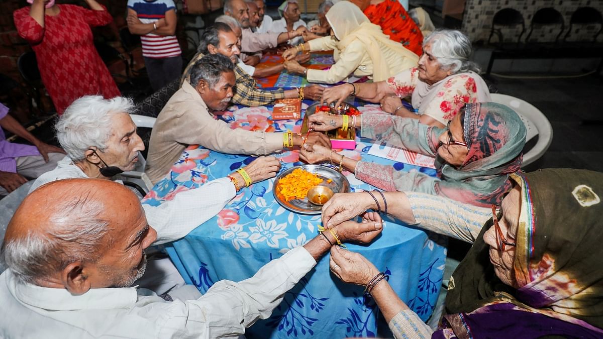 Women tie 'rakhi' on the wrists of men on the occasion of the 'Raksha Bandhan' festival, at an old age home in Jammu. Credit: PTI Photo