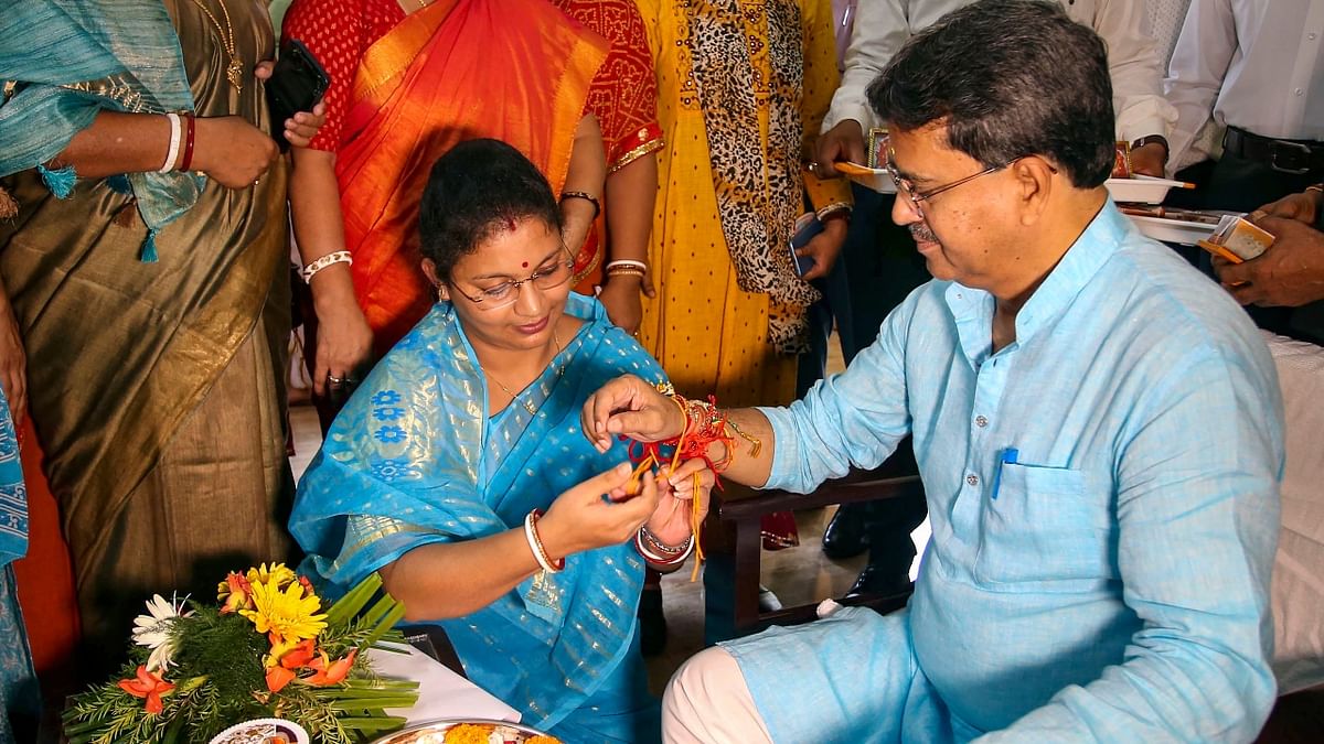 A woman tied a rakhi on the wrist of Tripura Chief Minister Manik Saha on the occasion of Raksha Bandhan in Agartala. Credit: PTI Photo