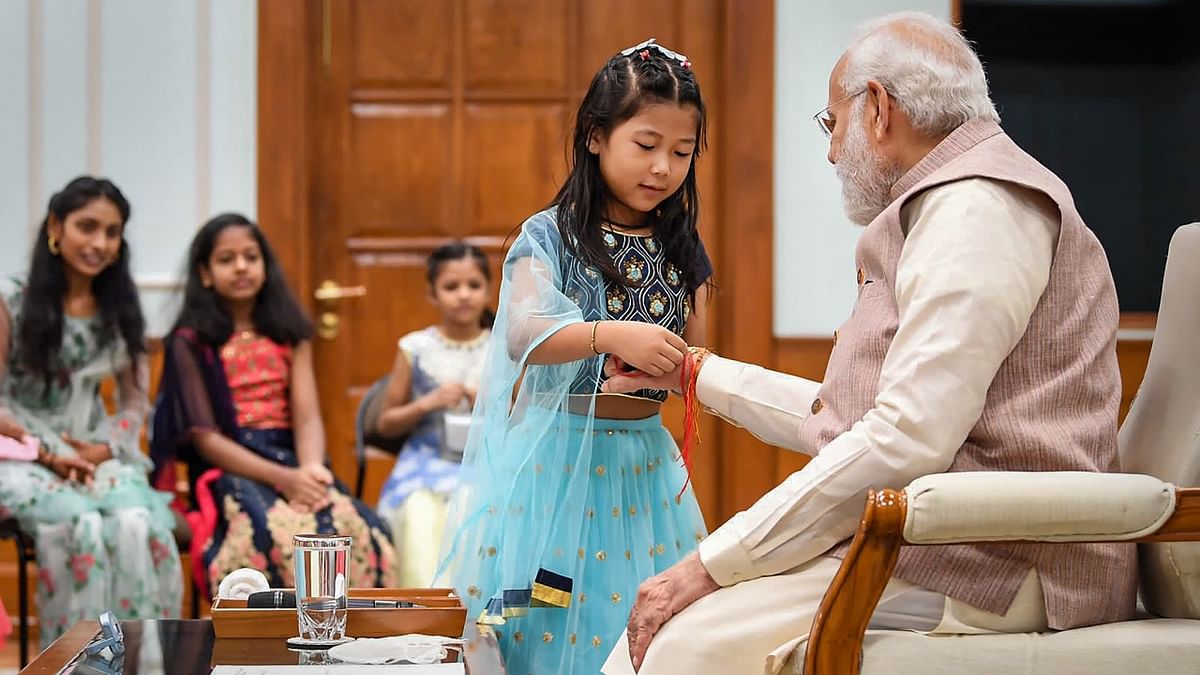 Reportedly, the daughters of sweepers, peons, gardeners, drivers, and other such members of the Prime Minister's Office staff tied rakhis on Modi's wrist. Credit: Twitter/@narendramodi