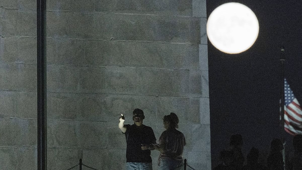 Stargazers enjoy the view of the full moon which was slightly larger and more vibrant than usual. It’s also the last supermoon of the year, according to NASA. Credit: AFP Photo