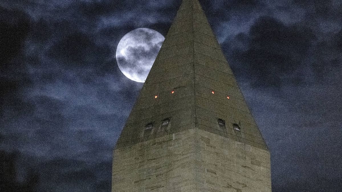 The moon is obscured by clouds as it passes behind the Washington Monument in Washington, DC. Credit: AFP Photo