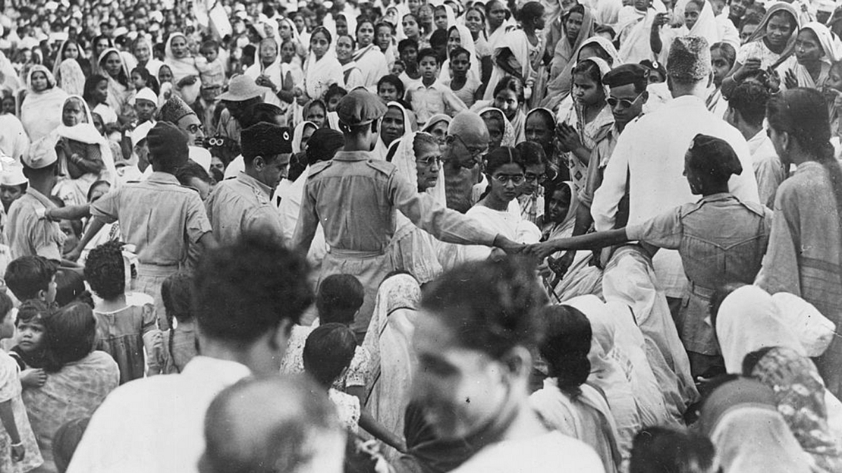 26 August, 1947: Mahatma Gandhi arriving through a surging crowd for a prayer meeting on the Calcutta Maidan, India. 100,000 Hindus and Muslims congregated to listen to Gandhi during the meeting in celebration of the Muslim festival Id-ul-Fitr. Credit: Photo by Keystone/Getty Images