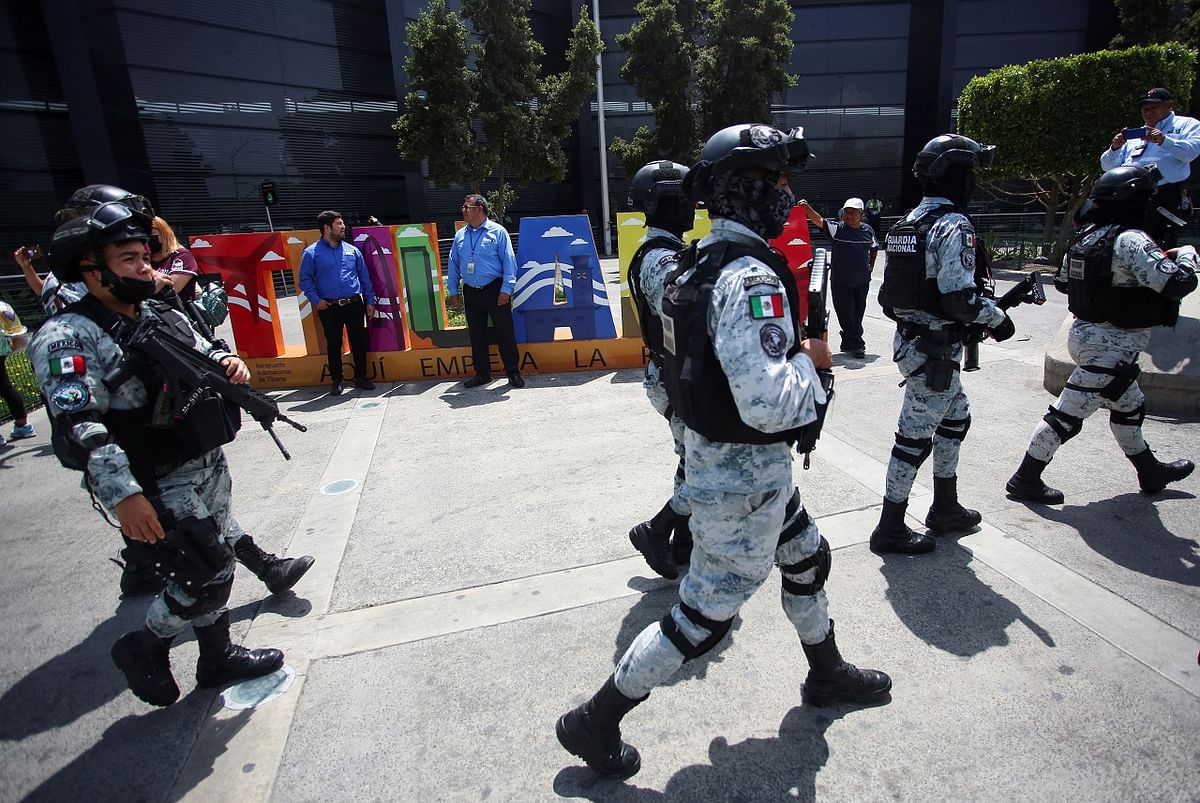 Members of security forces walk after arriving at the airport to reinforce security, after vehicles were set on fire by unidentified individuals, in Tijuana. Credit: Reuters Photo