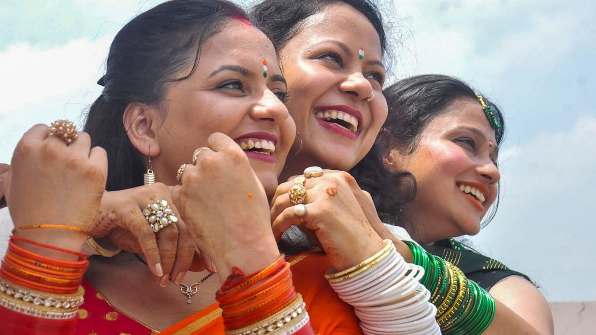 Women wearing tri-coloured clothes on the occasion of 76th Independence Day, pose for photos, in Moradabad. Credit: PTI Photo
