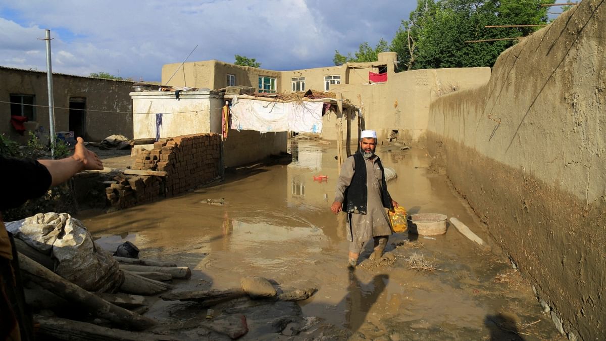 An Afghan man cleans up his damaged home after the heavy flood in the Khushi district of Logar, Afghanistan. Credit: Reuters Photo
