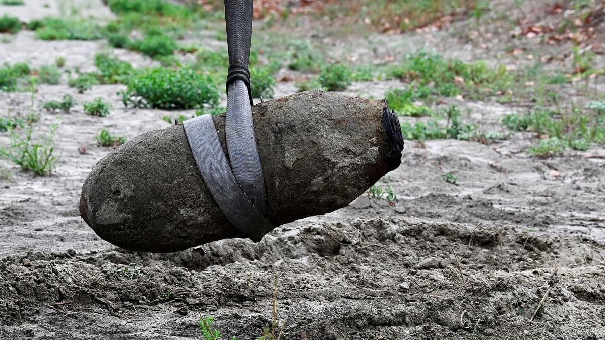 A World War II bomb is seen being removed after being discovered in the dried-up river Po which suffered from the worst drought in 70 years, in Borgo Virgilio, Italy. Credit: Reuters Photo