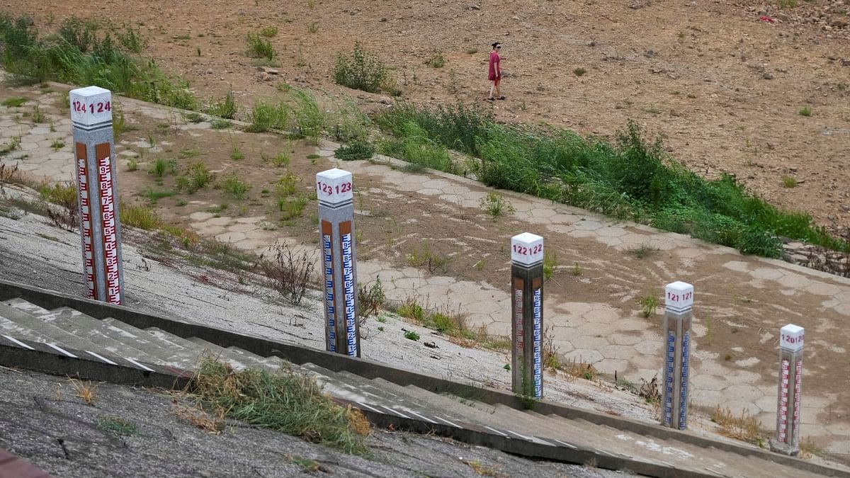 Water level poles emerge after waters receded in a reservoir as a woman walks on the dried-up bed reservoir, amid hot temperatures, while many regions from southwest to east of the country along the Yangtze river have been experiencing weeks of record-breaking heatwave in Changxing, China. Credit: Reuters Photo