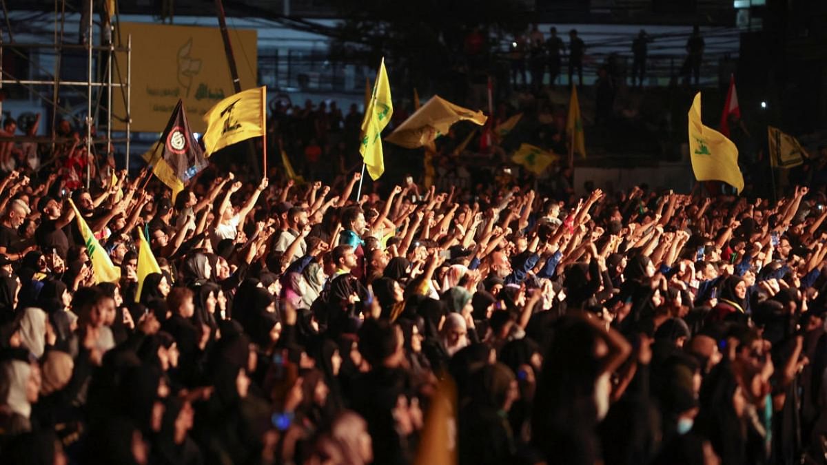 Supporters of Lebanon's Hezbollah leader Sayyed Hassan Nasrallah gesture as they hold Hezbollah flags during a rally in Beirut's southern suburbs, Lebanon. Credit: Reuters photo