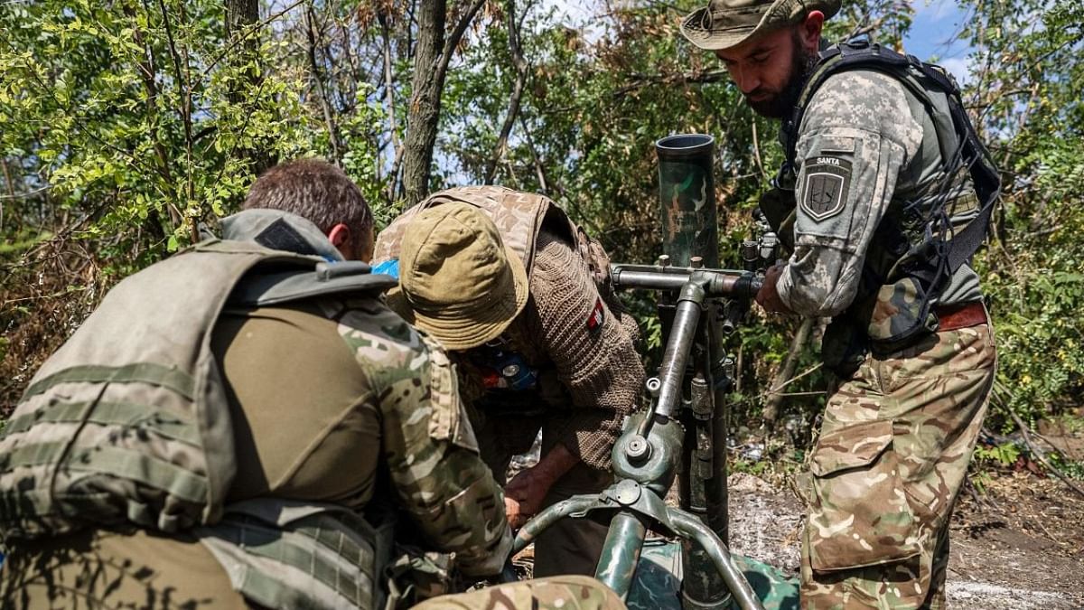 Ukrainian volunteer fighters prepare a mortar launcher at a position along the front line in the Donetsk region on August 22, 2022, amid the Russian invasion of Ukraine. Credit: AFP Photo