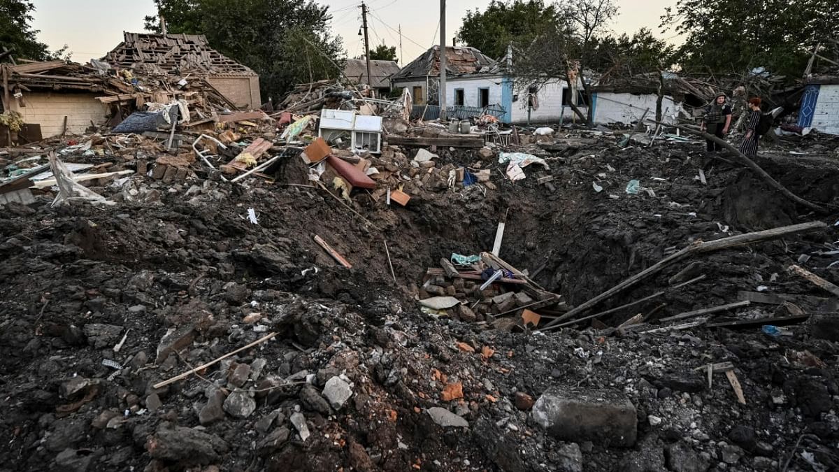People stand next to a residential house destroyed by a Russian military strike, as Russia's attack on Ukraine continues, in Chaplyne, Dnipropetrovsk region, Ukraine. Credit: Reuters photo