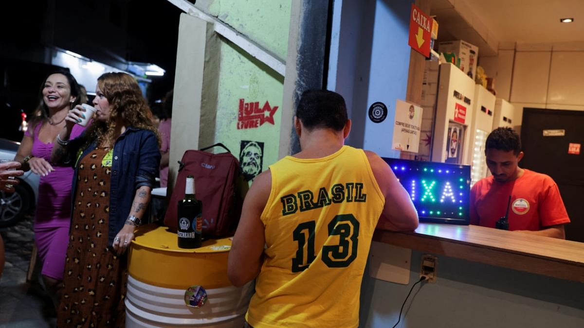 People talk outside a bar ahead of an interview of Brazil's former President and presidential candidate Luiz Inacio Lula da Silva with TV Globo's Jornal Nacional, in Rio de Janeiro, Brazil. Credit: Reuters photo
