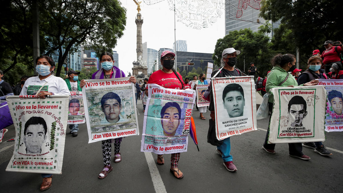 Relatives hold banners with images of the missing students from Ayotzinapa Teacher Training College, as they take part in a march to demand justice for their loved ones along Reforma avenue, in Mexico City, Mexico, August 26, 2022. Credit: Reuters Photo