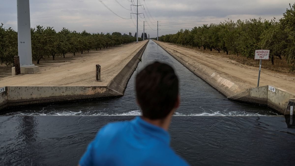 A local stands by an irrigation canal while extreme weather conditions including the record-breaking heat waves in California, US. Credit: Reuters Photo