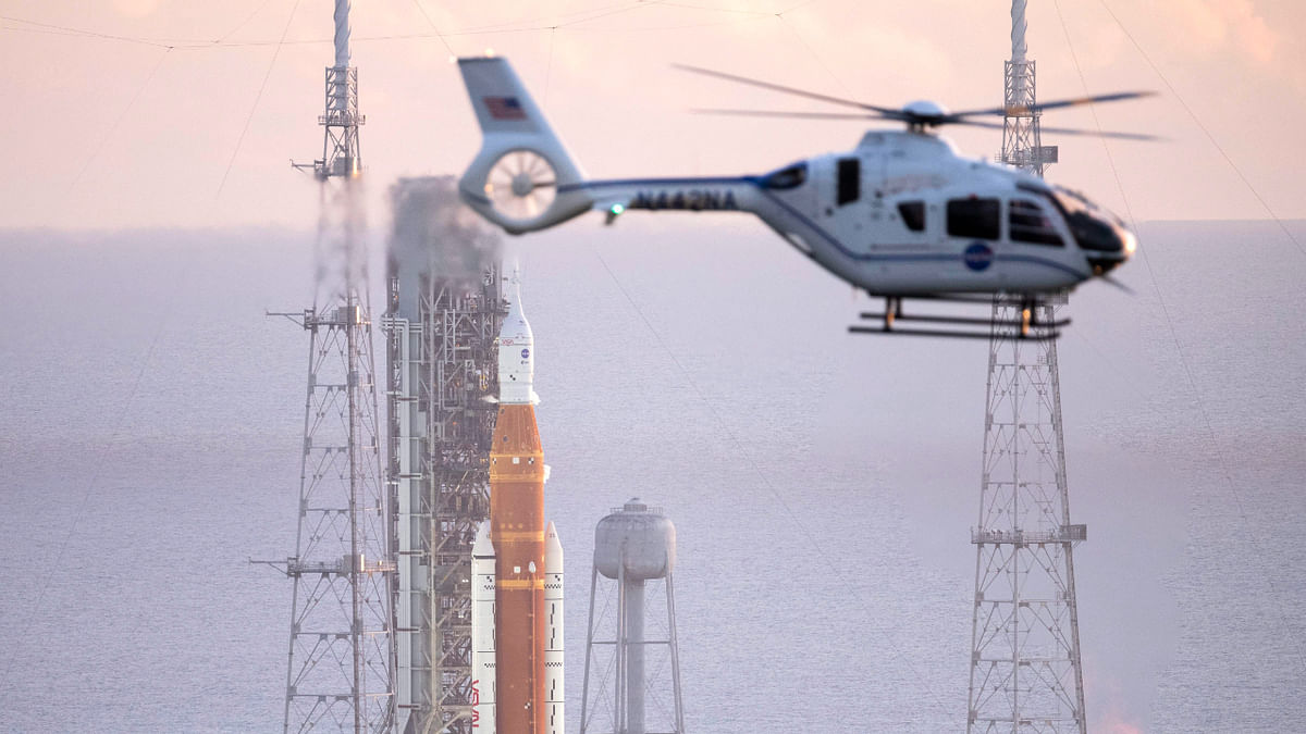 A NASA helicopter flies past the agency's Space Launch System (SLS) rocket with the Orion spacecraft atop the mobile launcher at Launch Pad 39B, Monday, Aug. 29, 2022, in Cape Canaveral, Fla. The launch was scrubbed. Credit: AP/PTI Photo