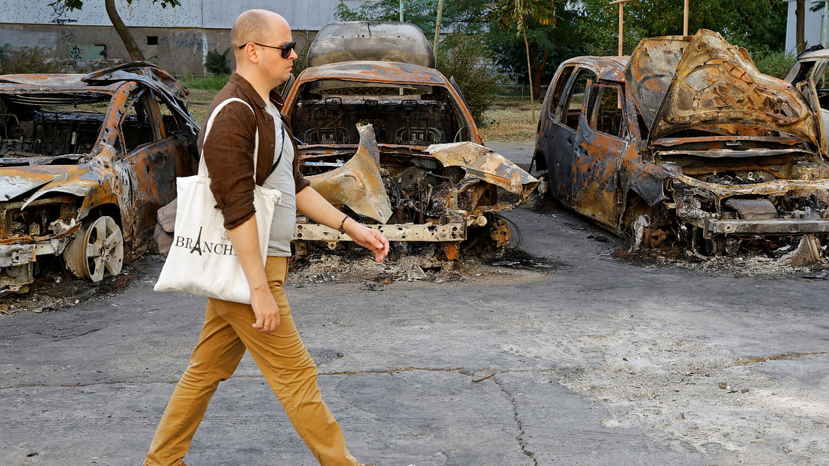 A local resident walks past cars destroyed by recent shelling in the course of Ukraine-Russia conflict in the Russian-controlled city of Enerhodar in Zaporizhzhia region, Ukraine August 30, 2022. Credit: Reuters Photo