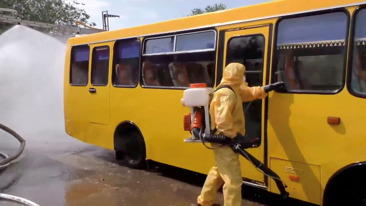 A person in a protective suit checks a bus during a drill conducted in case of radiation fallout in a location given as Zaporizhzhia region, Ukraine in this still image taken from handout video released August 31, 2022. Credit: Reuters Photo