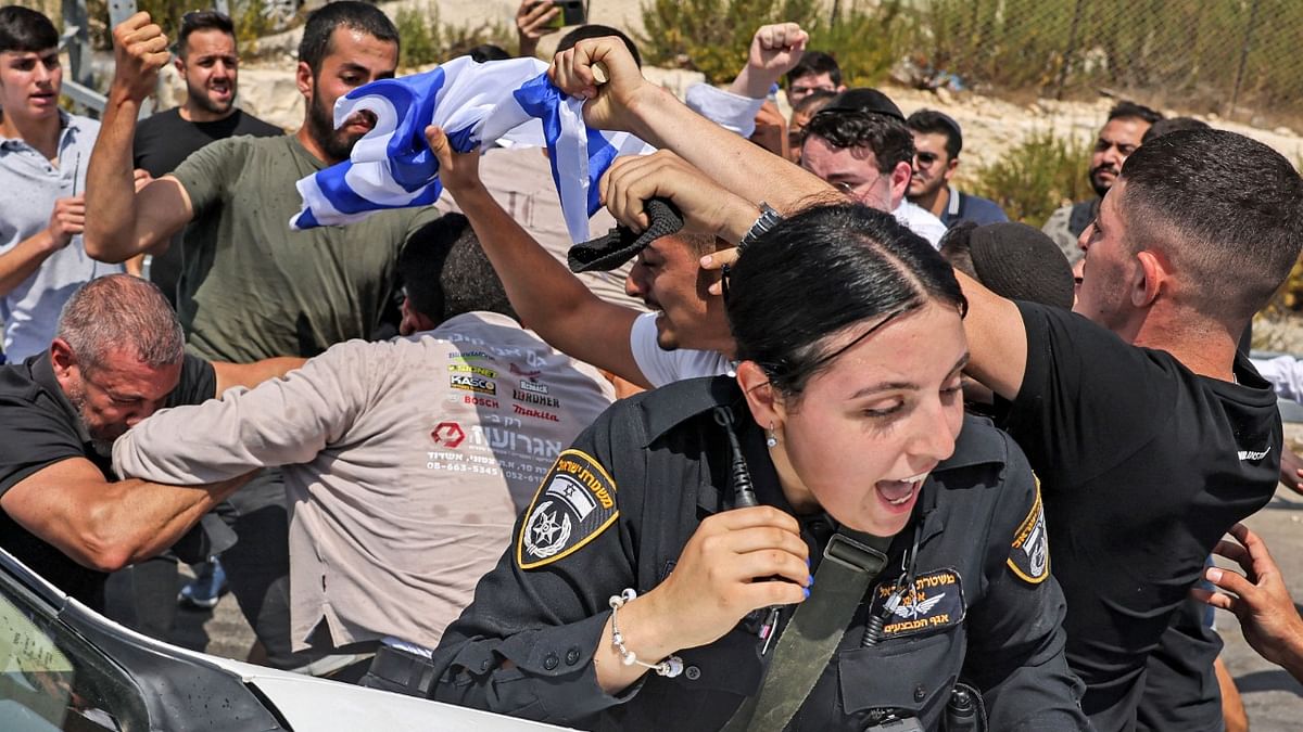 An Israeli policewoman calls out as behind her Israeli right-wing activists scuffle with a Palestinian man at the archaeological and religious site of the Tomb of Samuel at the Nabi Samuel village between Ramallah and Jerusalem in the occupied West Bank. Credit: AFP Photo