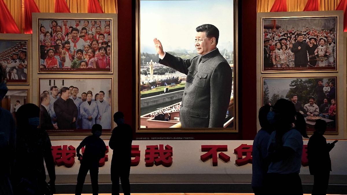 People stand in front of images of Chinese President Xi Jinping at the Museum of the Communist Party of China in Beijing. Credit: AFP Photo