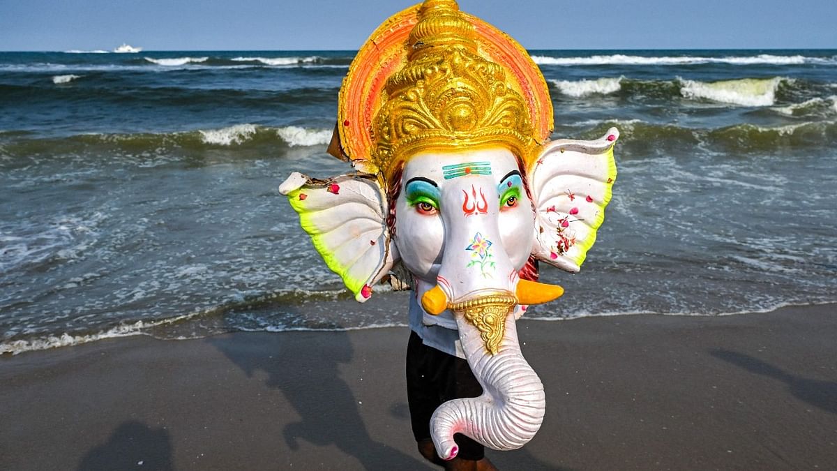 A devotee carries an idol of elephant-headed Hindu god Ganesha for immersion in the Bay of Bengal on the fifth day of the ten-day-long Ganesh Chaturthi festival in Chennai. Credit: AFP Photo