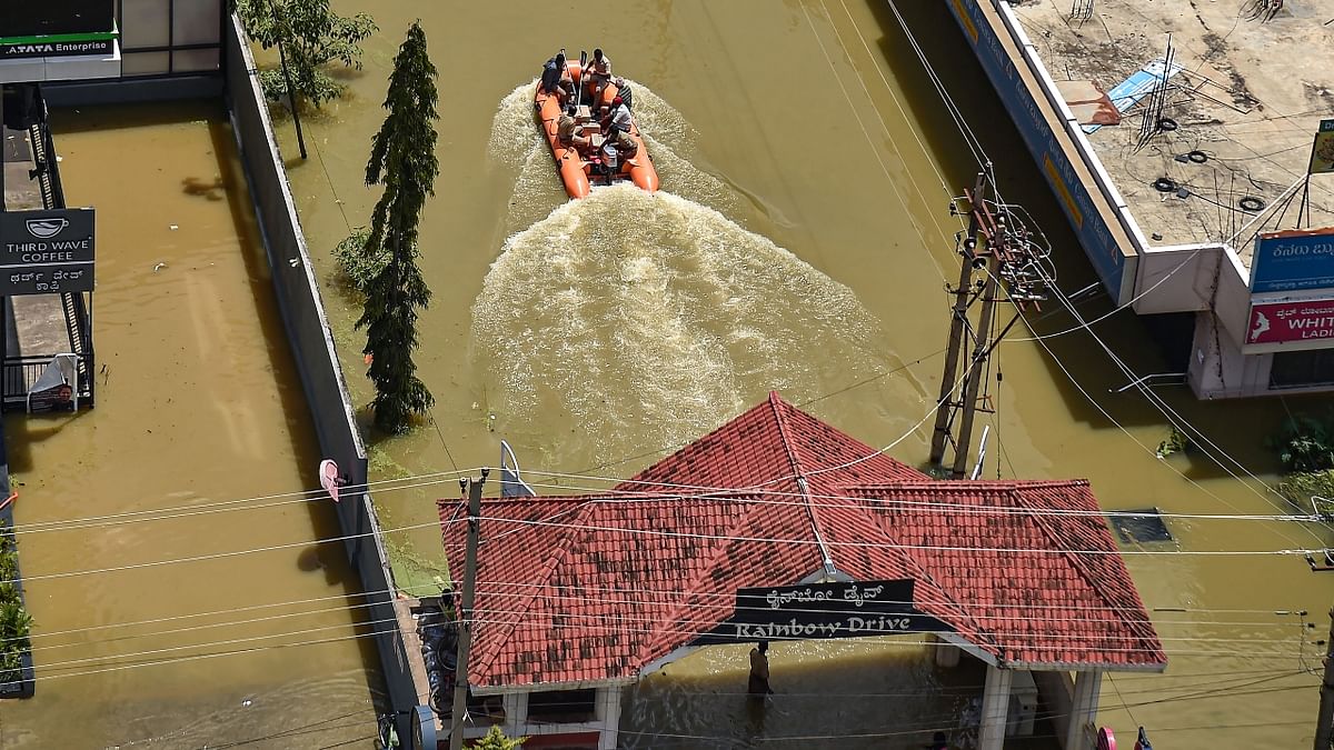 Fire fighters evacuate residents from flooded Rainbow Drive Layout after heavy monsoon rains in Bengaluru's Sarjapur. Credit: PTI Photo