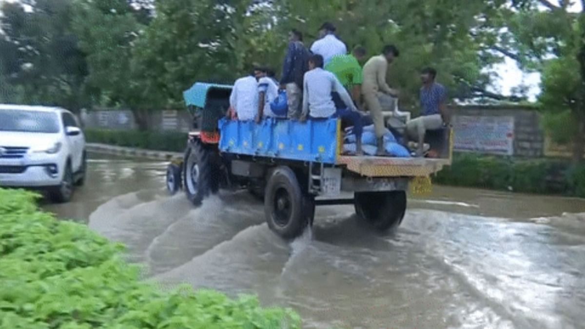 With Bengaluru reeling under severe waterlogging due to incessant heavy rains, many IT professionals in India's Silicon Valley resorted to tractors to reach their workplaces. Credit: ANI Photo