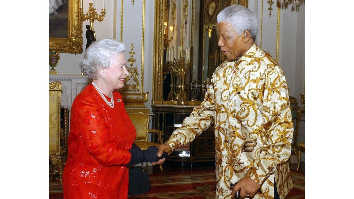 Queen Elizabeth II greets former South African President Nelson Mandela during a reception at Buckingham Palace in London to mark the centenary of the Rhodes Trust on October 20, 2003. Credit: AFP Photo