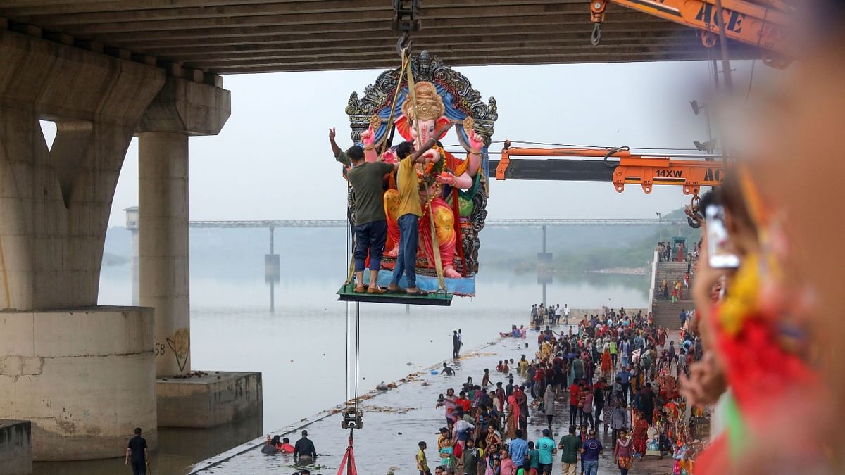 A crane lowers an idol of Lord Ganesh into a pond on the last day of the Ganesh Chaturthi festival, in Ahmedabad. Credit: PTI Photo