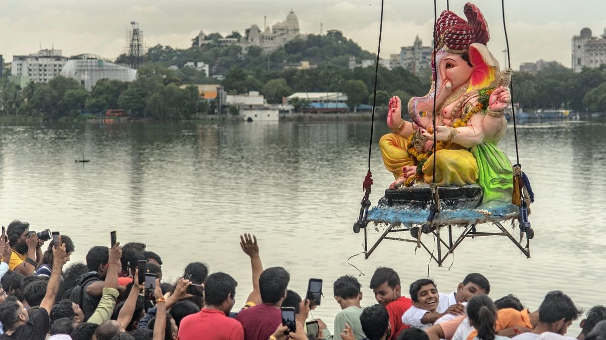 Devotees immerse an idol of Lord Ganesha on the last day of Ganesh Chaturthi, at Hussain Sagar Lake in Hyderabad. Credit: PTI Photo