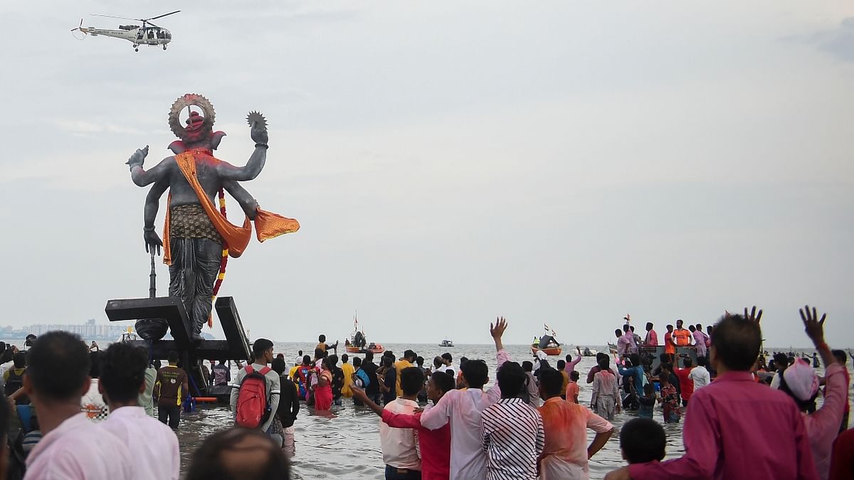 Devotees carry an idol of Lord Ganesha for immersion in the Arabian sea, at Girgaon Chowpatty in Mumbai. Credit: PTI Photo