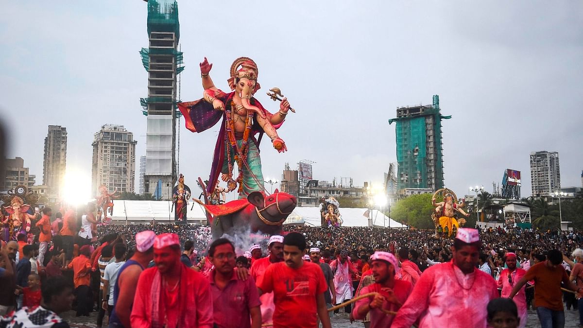 Devotees carry an idol of Lord Ganesha for immersion in the Arabian sea, at Girgaon Chowpatty in Mumbai. Credit: PTI Photo