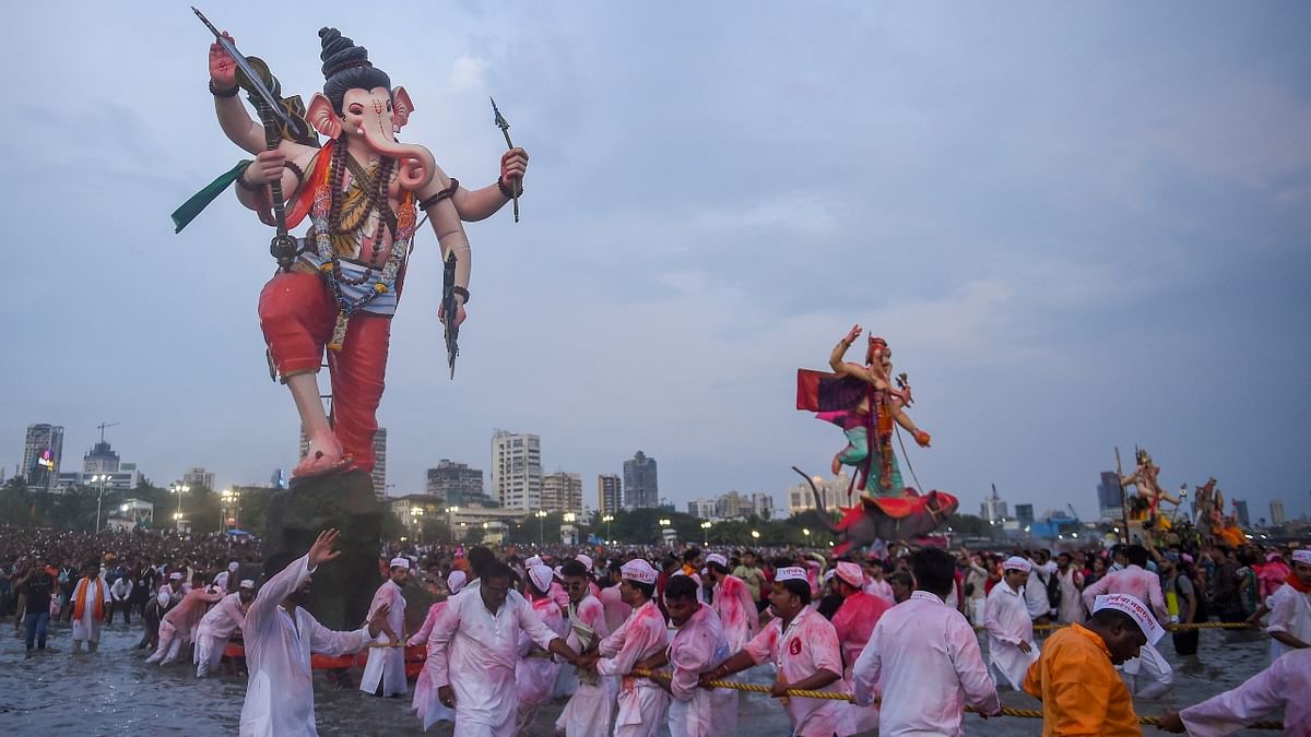 Devotees carry an idol of Lord Ganesha for immersion in the Arabian sea, at Girgaon Chowpatty in Mumbai. Credit: PTI Photo