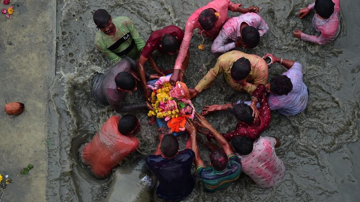 Hindu devotees immerse an idol of the elephant-headed Hindu deity Ganesh at an artificial pond adjacent to Sabarmati River on the last day of 'Ganesh Chaturthi' festival in Ahmedabad on September 9, 2022. Credit: AFP Photo