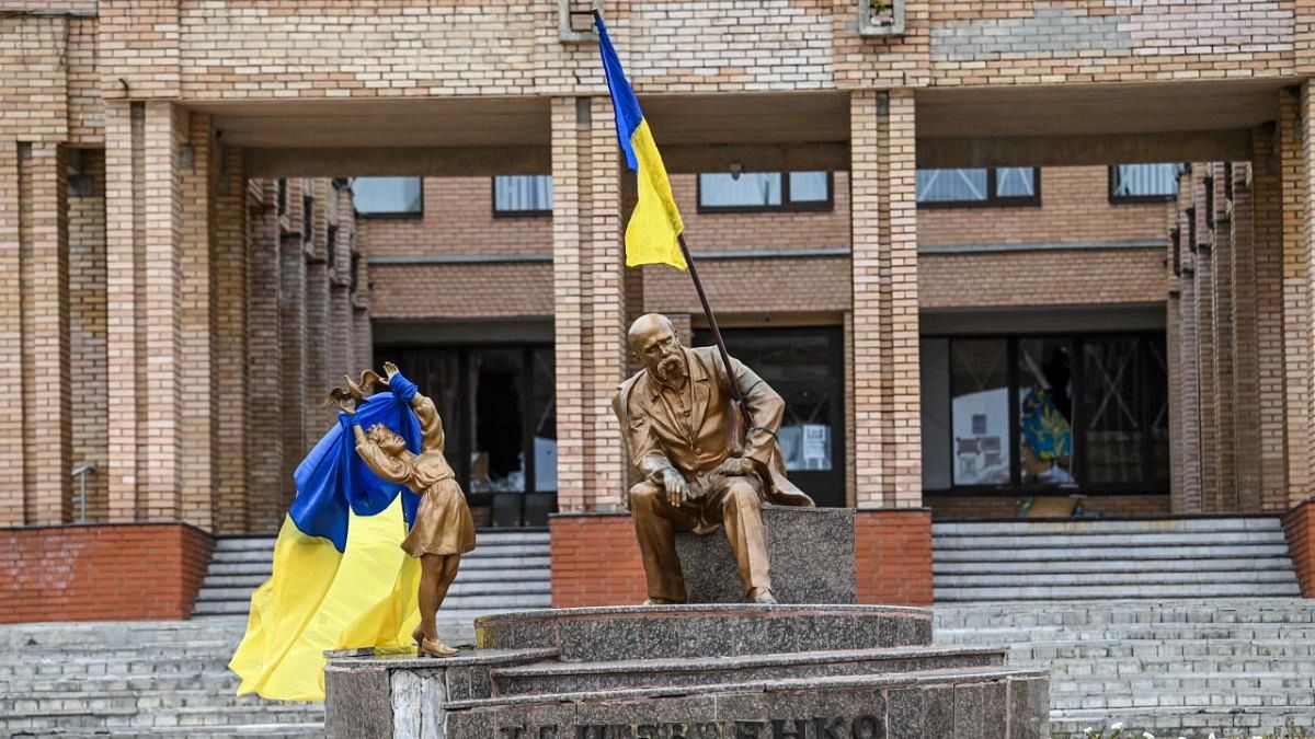 A photograph taken on September 10 , 2022, shows Ukrainian flags placed on statues in a square in Balakliya, Kharkiv region, amid the Russian invasion of Ukraine. Credit: AFP Photo
