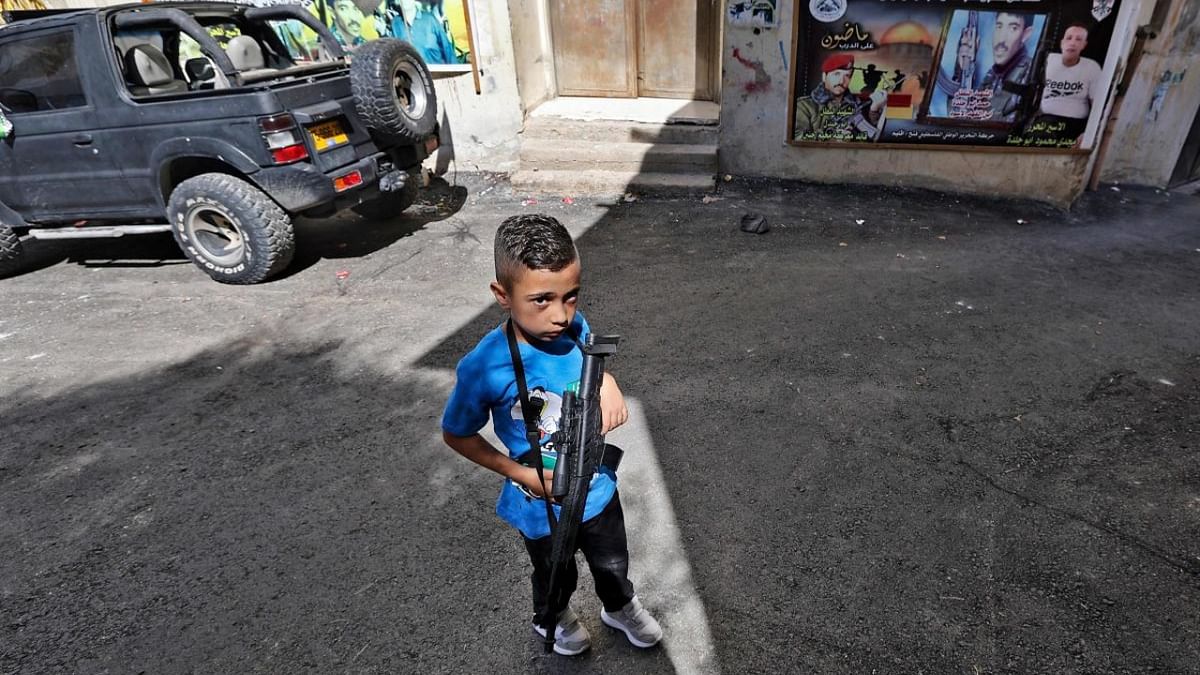 A Palestinian boy carries a toy rifle during the funeral procession of Hamad Mustafa Hussein Abu Jelda, 24, in the Jenin refugee camp in the occupied West Bank. Credit: AFP Photo