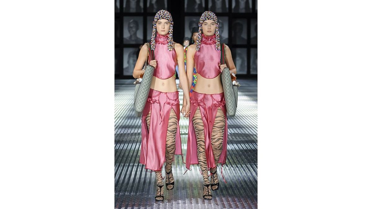 The pairs donned Lurex gowns with shark-bite cutouts, two tailored silk ensembles embroidered with cherry blossoms, two pinstripe suits with ladylike handbags. Credit: Gucci/Facebook