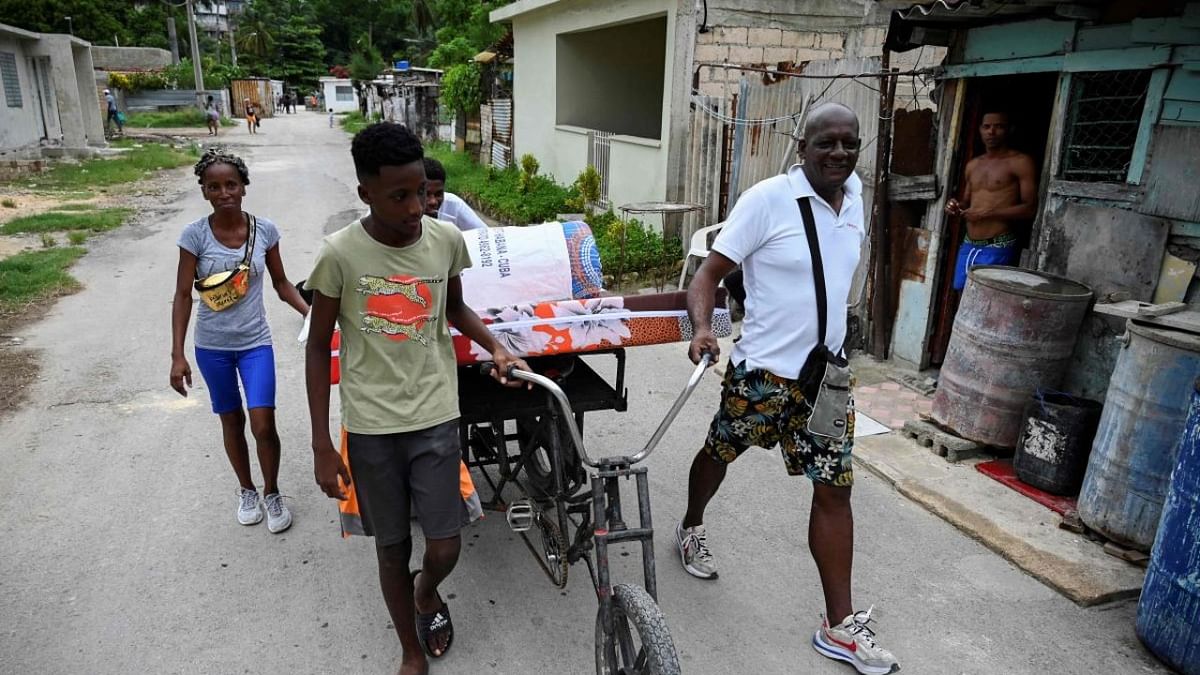 A Cuban family transport personal belongings to a safe place in the Fanguito neighborhood in Havana, on September 26, 2022 ahead of the arrival of Hurricane Ian. Credit: AFP Photo