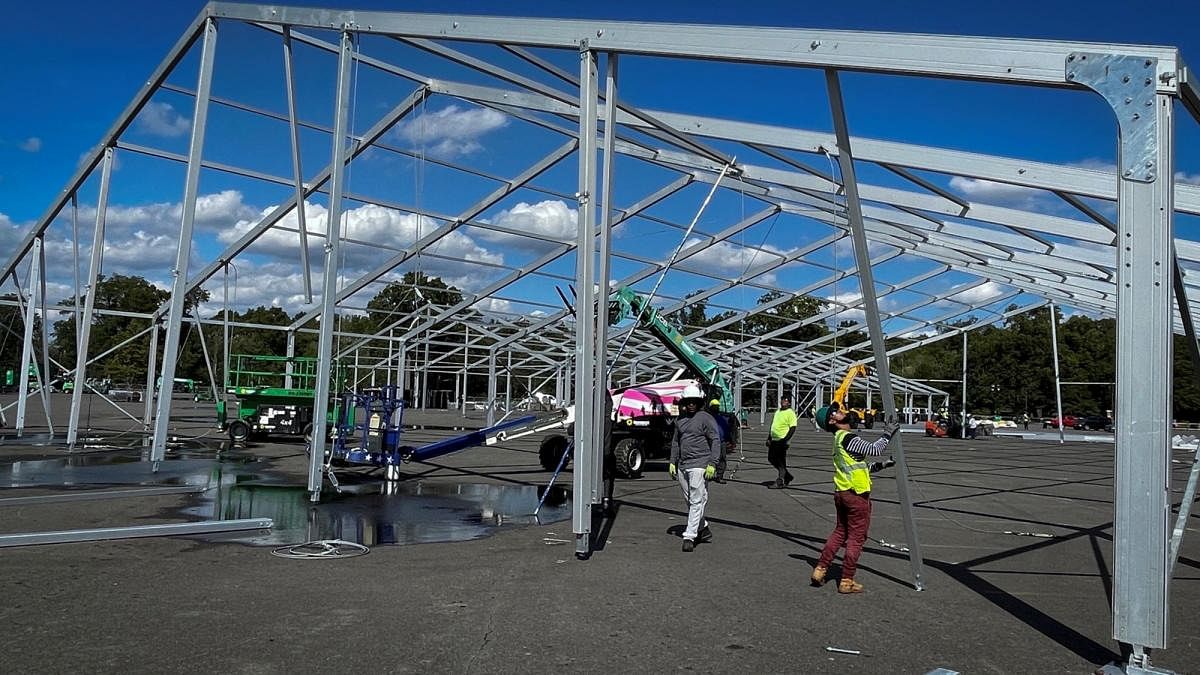 Workers erect a structure as the city prepares to open an emergency center to process and temporarily house adult migrants arriving by bus to New York from Texas in Orchard Beach Park in the Bronx borough of New York City. Credit: Reuters photo