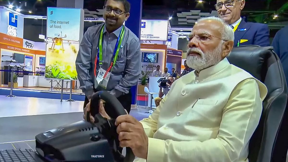 PM Modi drove a remote-controlled car at a stall during the inauguration of the Congress. Credit: PTI Photo