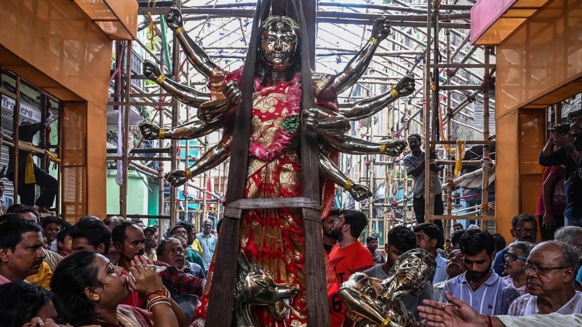 Durga Puja celebrations kicked off over a month in advance this year to celebrate the festival earning a UNESCO tag of untangible heritage. In this photo, devotees gather near an idol of Hindu goddess Durga made of alloy consisting of eight different metals as it is being placed inside a pandal. Credit: AFP Photo